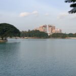 Calm lake with buildings and trees in background