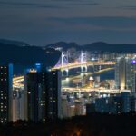 a city at night with a bridge in the background