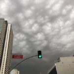 a green traffic light in front of tall buildings