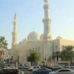 a large building with towers and domes with Jumeirah Mosque in the background