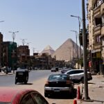 Pyramids visible over buildings and street traffic