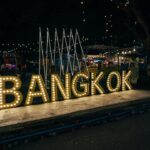 a sign that says bangkok lit up at night