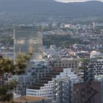 a view of a city with tall buildings and mountains in the background