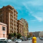 cars parked in front of brown concrete building during daytime