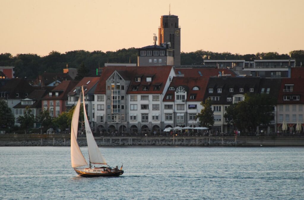 Sailboat on the water with cityscape background.