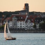 Sailboat on the water with cityscape background.