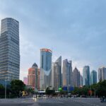 a city street with tall buildings in the background