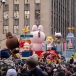 Parade float with cartoon characters and balloons.