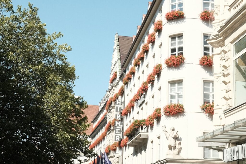 a tall white building with flowers on the windows