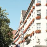 a tall white building with flowers on the windows