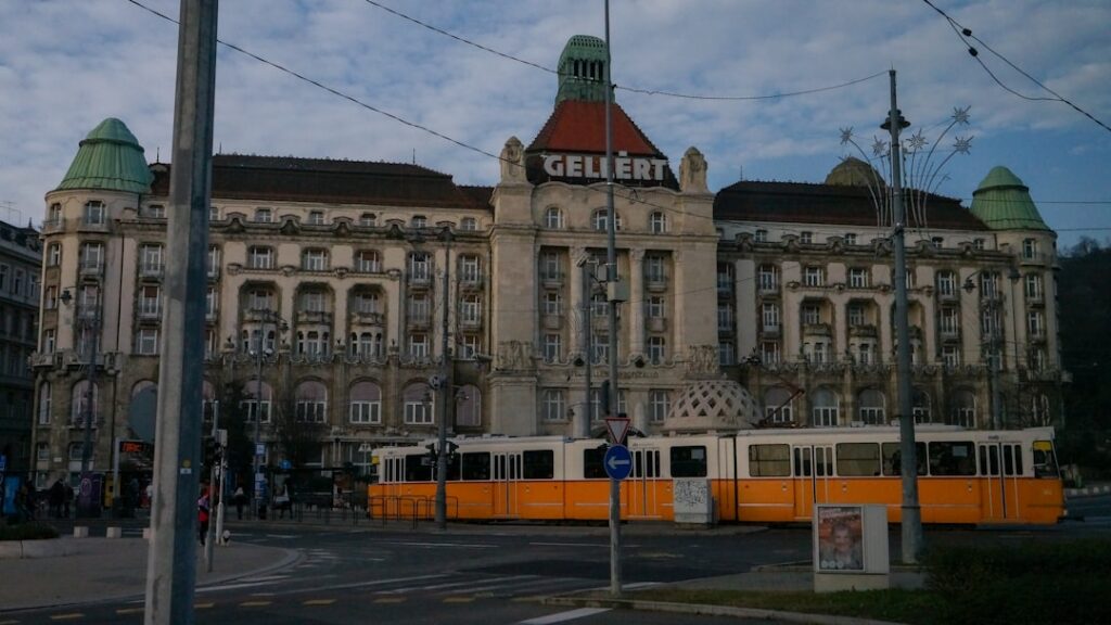 A grand building with a tram in front
