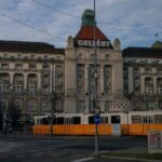A grand building with a tram in front