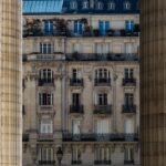 Buildings in paris framed by columns.