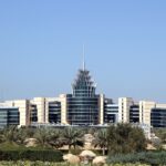 white and blue concrete building near green trees under blue sky during daytime