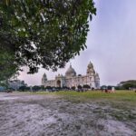 brown concrete building near green trees under white sky during daytime