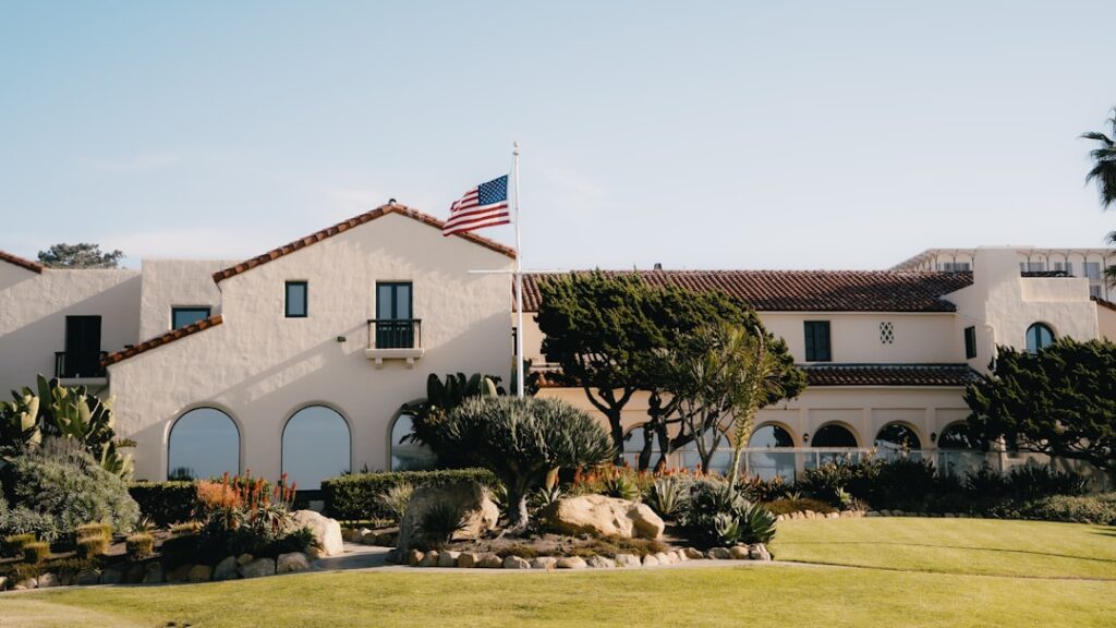 Large building with spanish architecture and american flag.