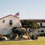 Large building with spanish architecture and american flag.