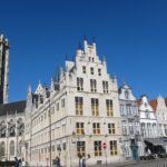 a large building with a tall tower next to other buildings