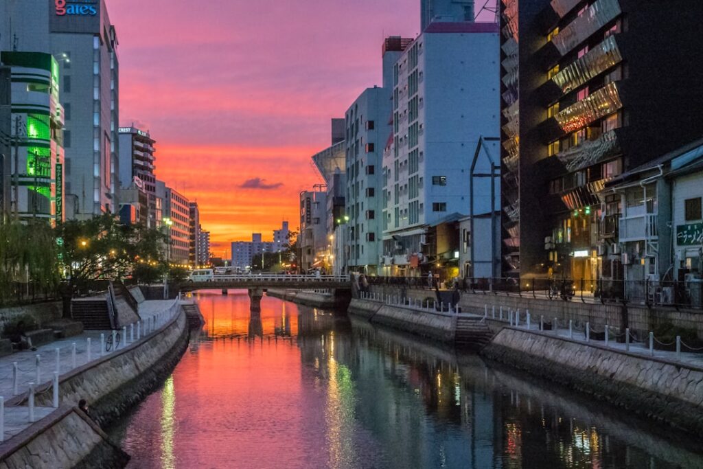 river between high rise buildings during night time