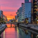 river between high rise buildings during night time