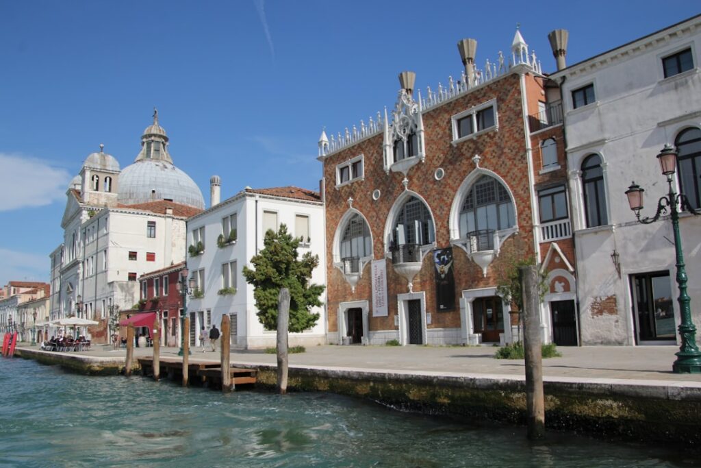 white and brown concrete building near body of water during daytime