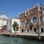white and brown concrete building near body of water during daytime