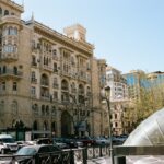 a city street filled with traffic next to tall buildings