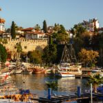 a harbor filled with lots of boats next to a city